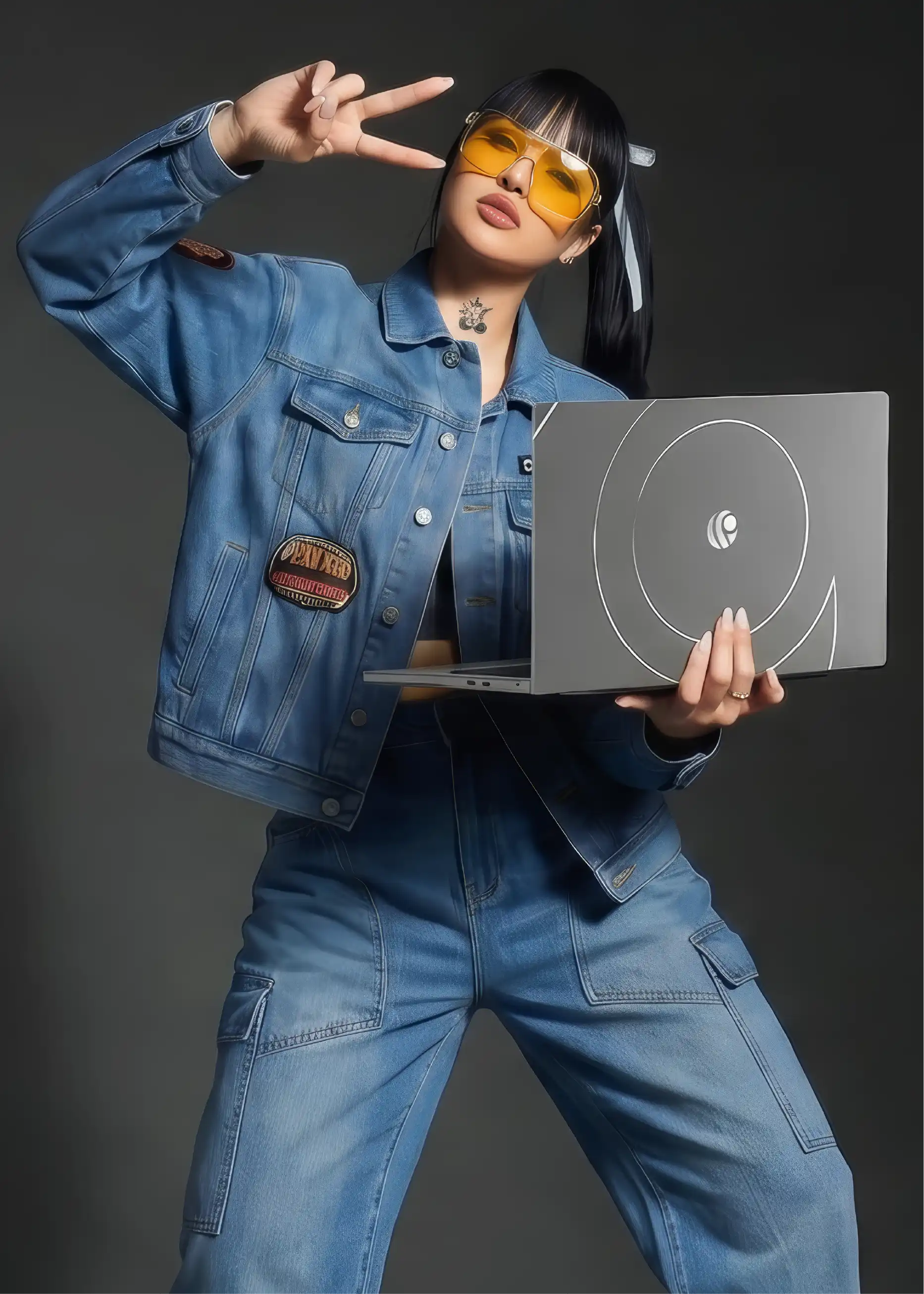 Creator in a denim outfit posing while holding an open Primebook laptop
